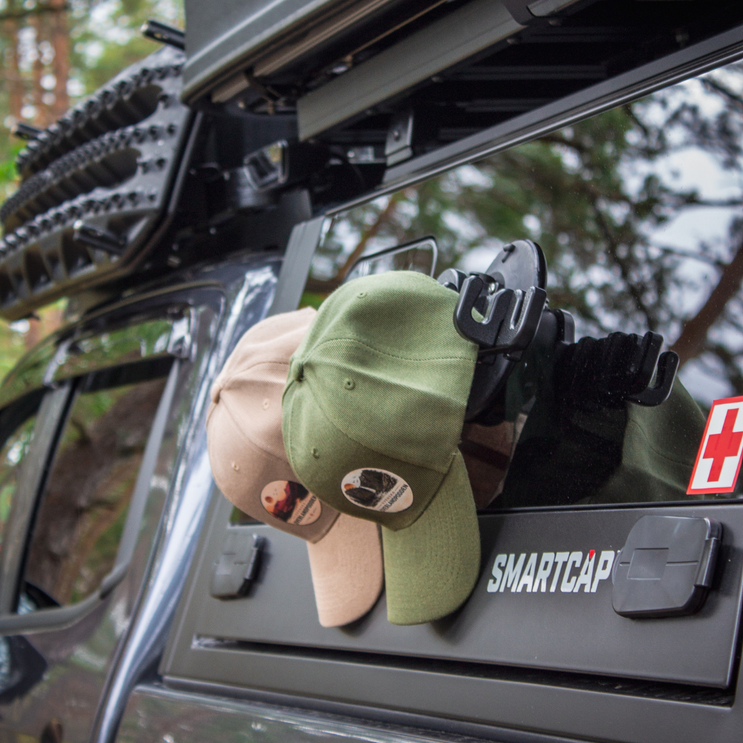SeaSucker Hook Rack holding two hats mounted to a truck camper shell